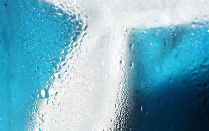 Water droplets on glass with blue background