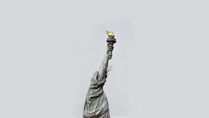 Statue of Liberty's torch against a grey sky