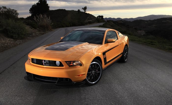 Orange Ford Mustang Boss 302 on a winding road