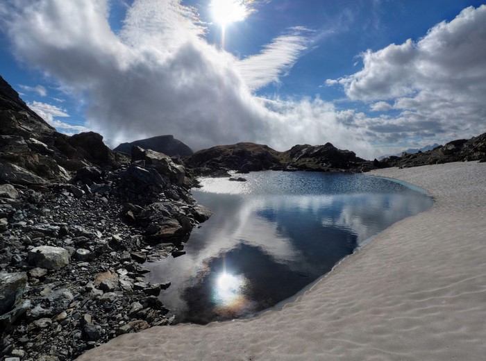 Mountain lake with snow and clouds