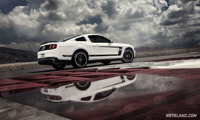 White Ford Mustang Boss 302 on a wet track
