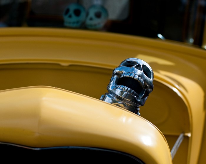 Yellow car with chrome skull hood ornament