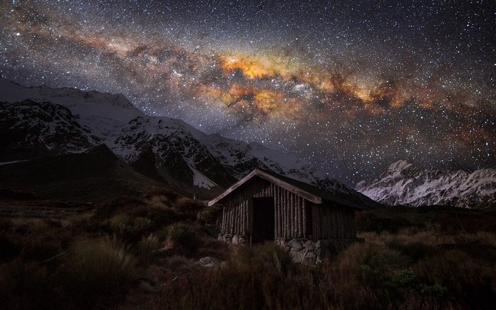 Wooden hut under the Milky Way in New Zealand mountains