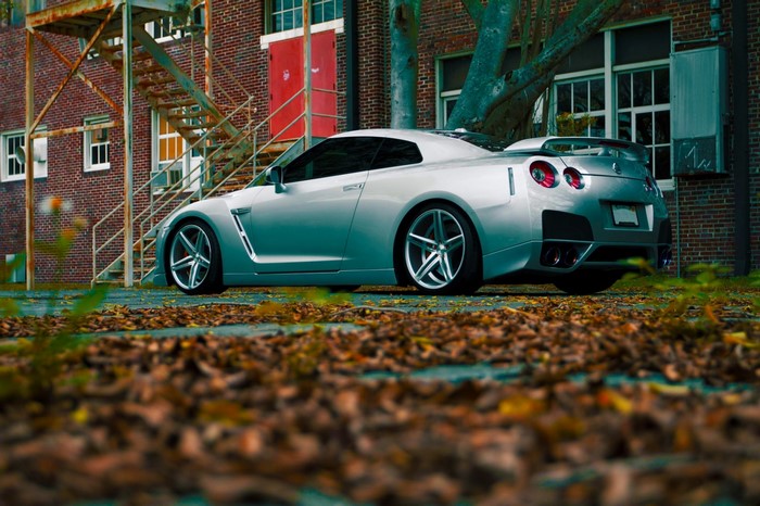 Silver Nissan GT-R parked near a brick building