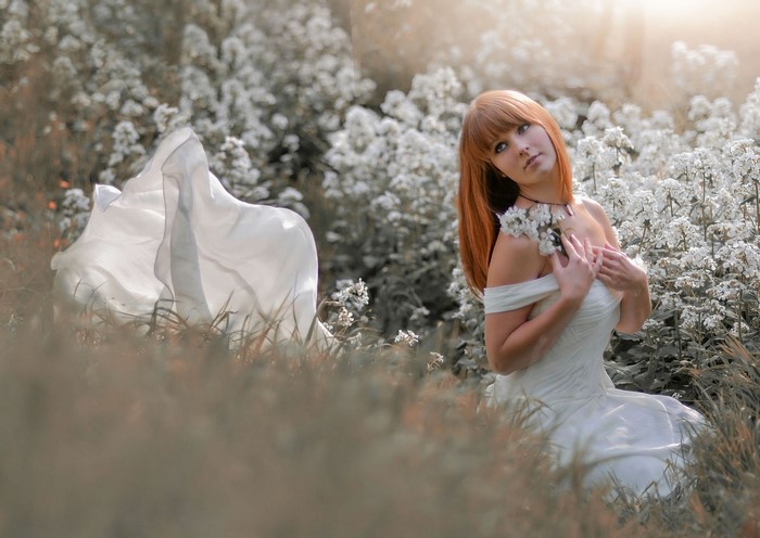 Woman in white dress in a field of flowers