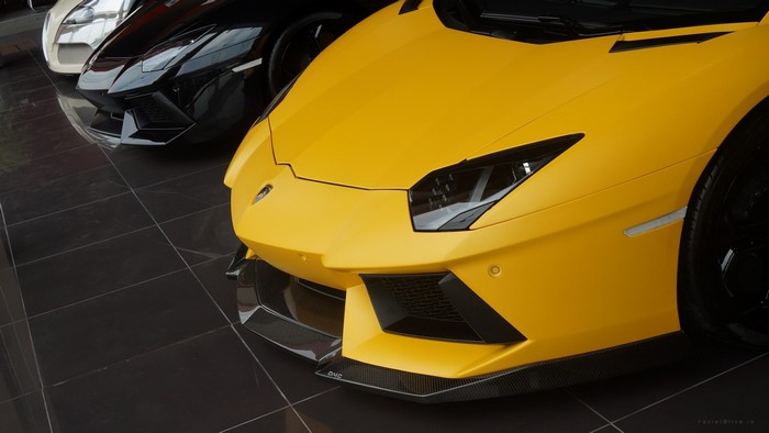 Yellow Lamborghini Aventador parked with other cars