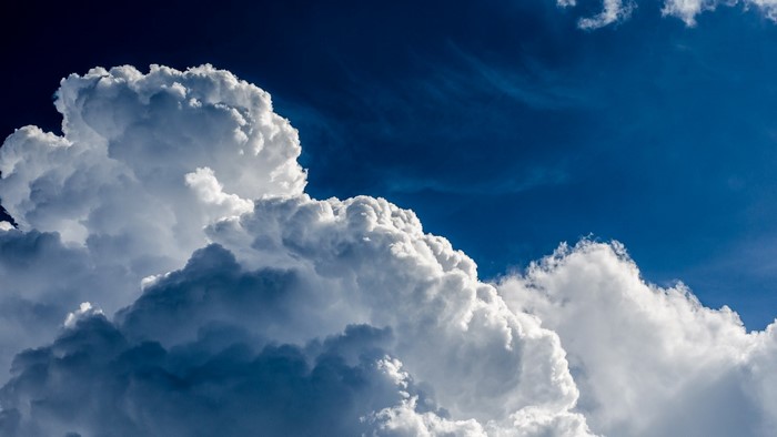 Cumulus clouds against a deep blue sky