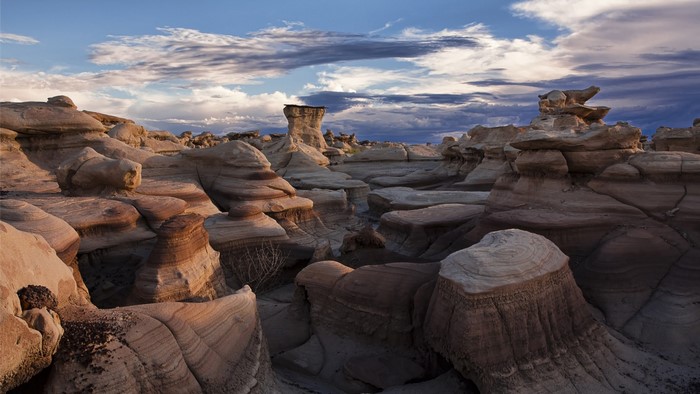 Badlands rock formations under a cloudy sky