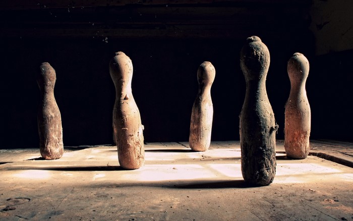 Old wooden bowling pins in a dark room