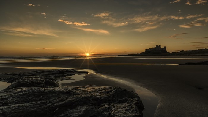 Bamburgh Castle at sunset on the coast of England