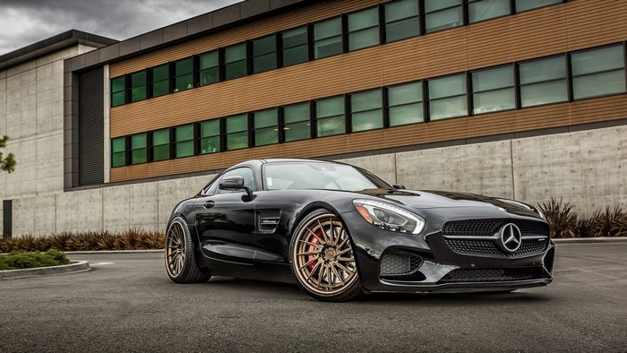Black Mercedes-AMG GT parked in front of a modern building