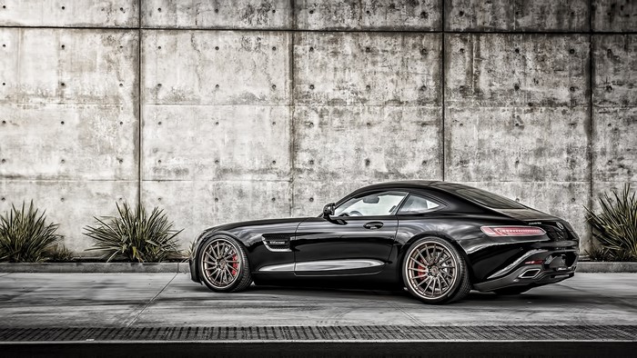 Black Mercedes-AMG GT S Coupe parked by concrete wall