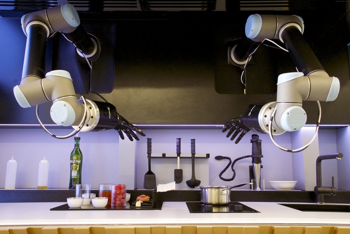 Robotic arms preparing food in a modern kitchen