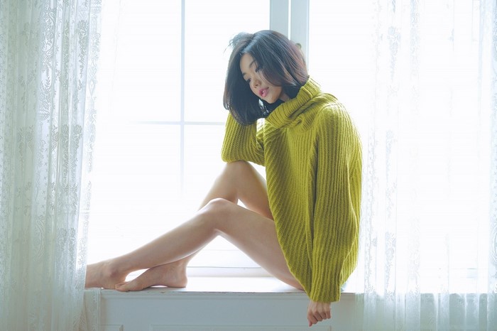 Brunette Woman in Green Sweater by Window