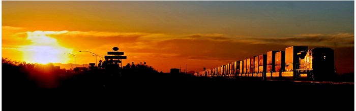Train silhouetted against a vibrant sunset sky