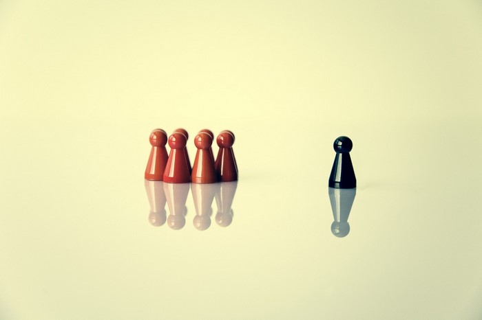 Red and black game pawns on reflective surface