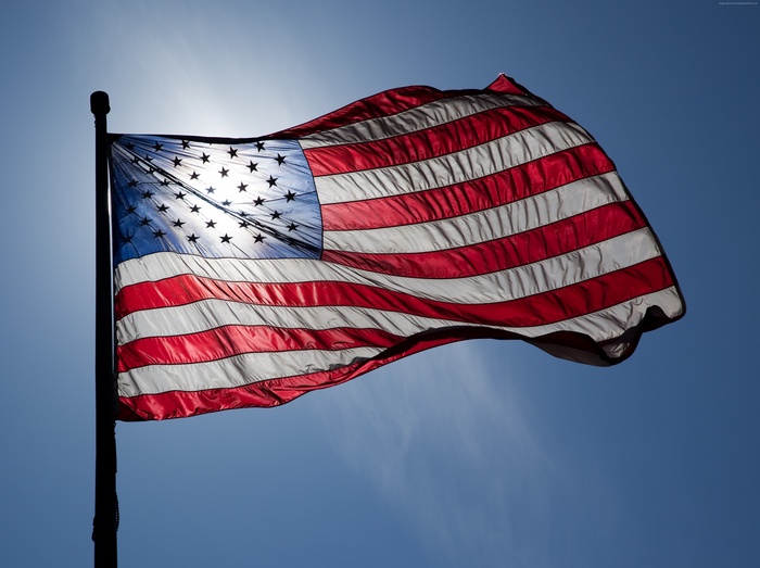 American flag waving in the sun against a blue sky