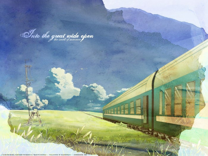 Train traveling through a grassy field with clouds
