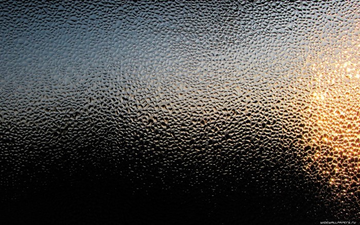 Sunlight on textured glass with water drops