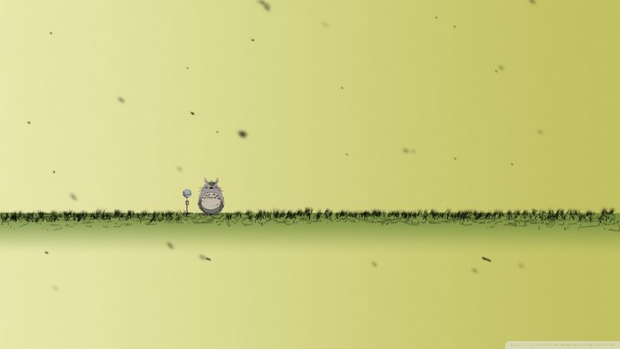 Totoro in a grassy field with falling particles