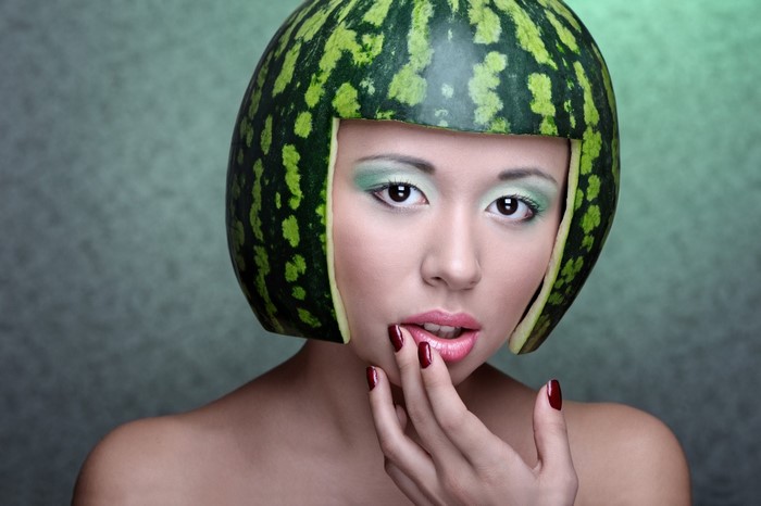Woman with watermelon as a helmet