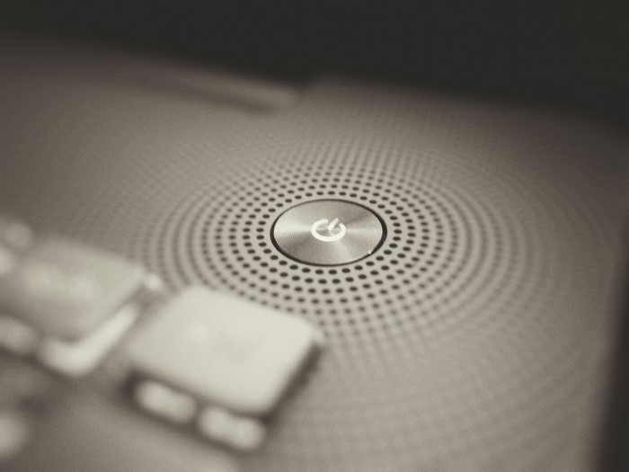 Close-up of a laptop power button with speaker grille