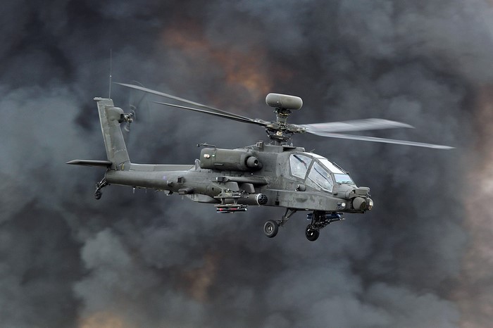 Boeing AH-64 Apache military helicopter in smoke