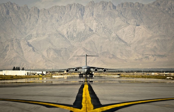 Boeing C-17 Globemaster III on a runway with mountains
