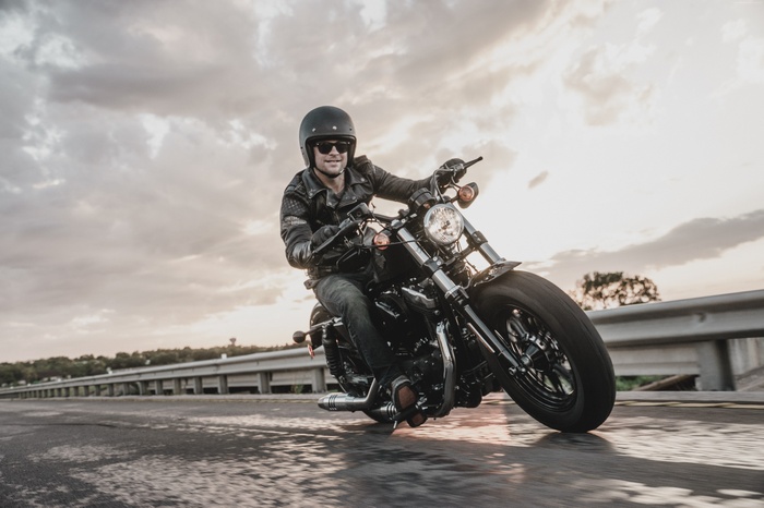 Man riding a black Harley Davidson Iron 883 motorcycle