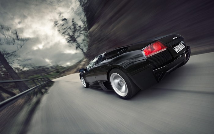 Black Lamborghini Murcielago LP640 4 driving on a road