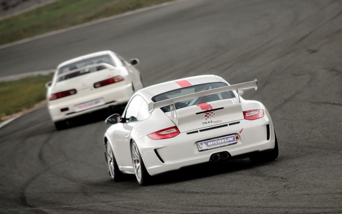 White Porsche 911 GT3 and Honda Integra on a Race Track