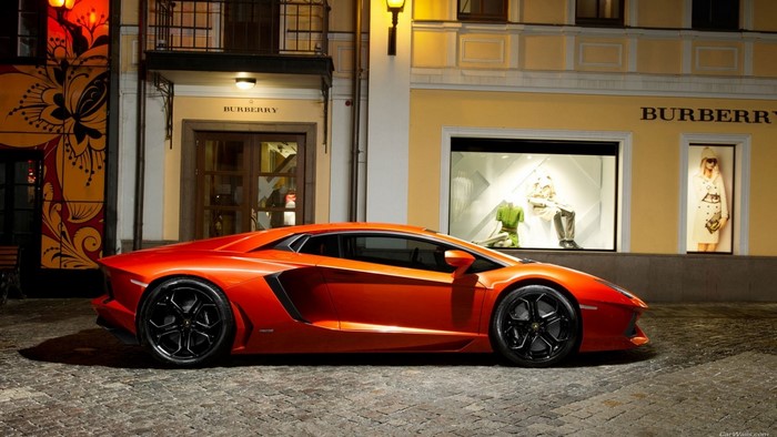 Orange Lamborghini Aventador parked in front of Burberry store
