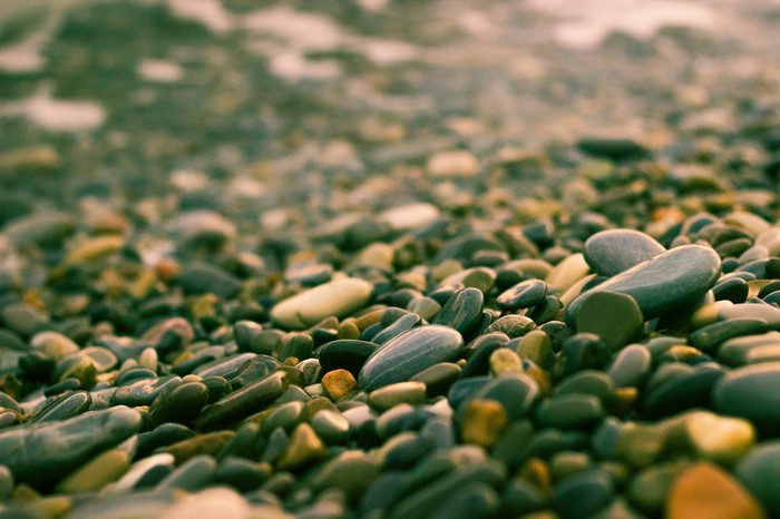 Close-up of wet pebbles on a beach with gentle waves