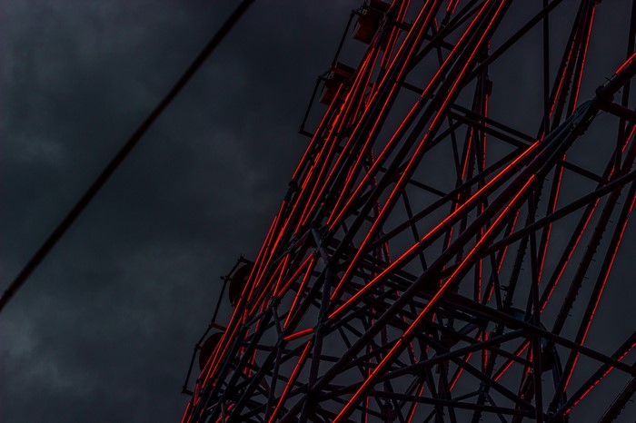 Ferris wheel with red lights against dark sky
