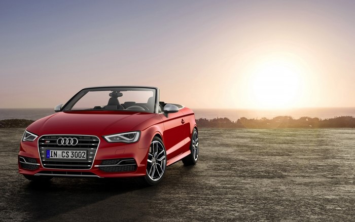 Red Audi S3 Convertible parked by the ocean at sunset