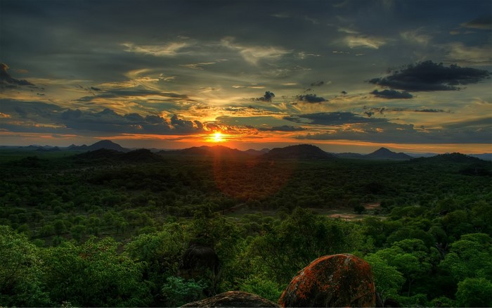 Sunset over a forested landscape with hills