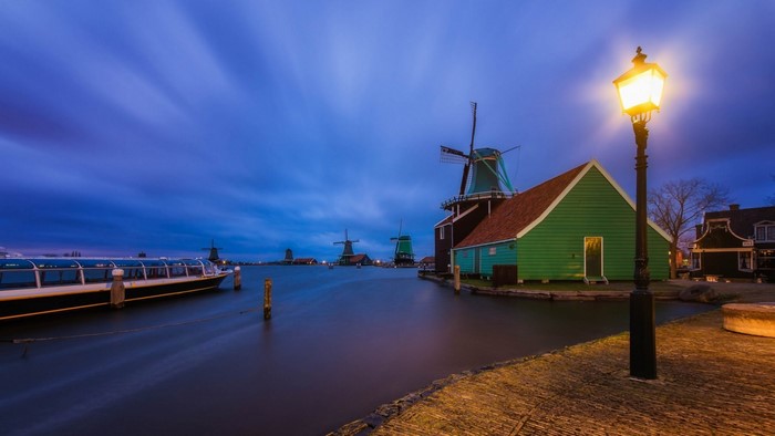 Windmills and boat on a waterway at dusk in the Netherlands