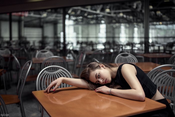 Woman resting her head on a table in a cafe
