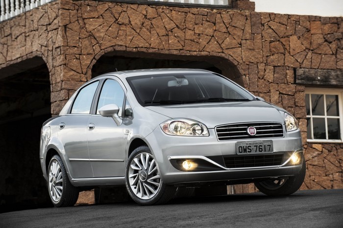 Silver Fiat Linea sedan parked in front of a stone building