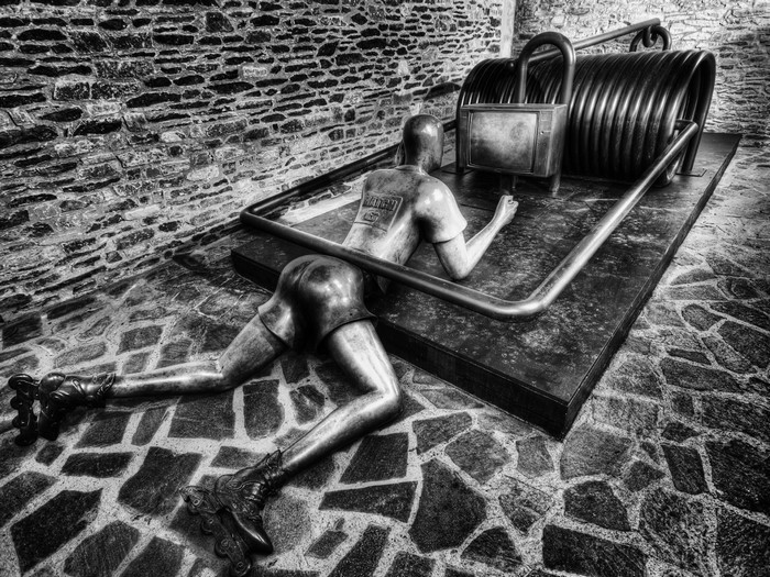 Sculpture of a person on roller skates trapped in a mousetrap