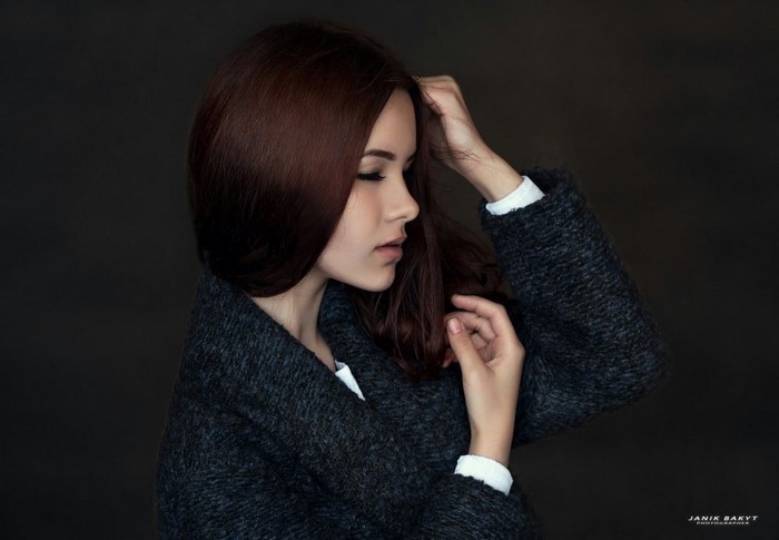 Woman with dark hair in a dark coat, side view portrait