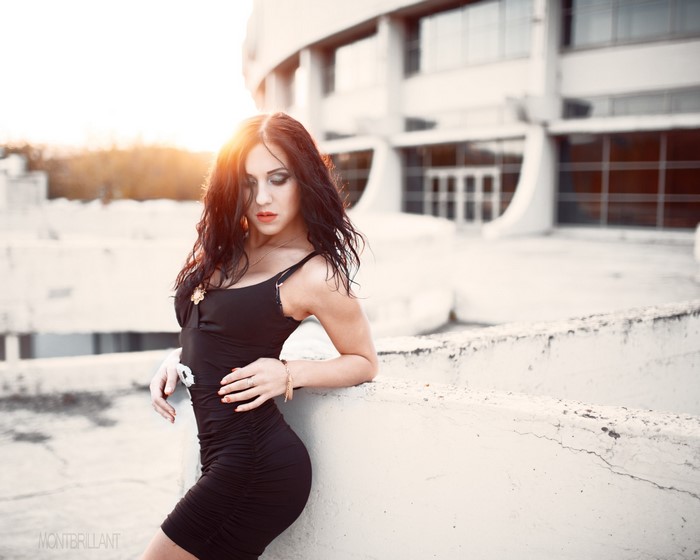 Woman in black dress posing outdoors