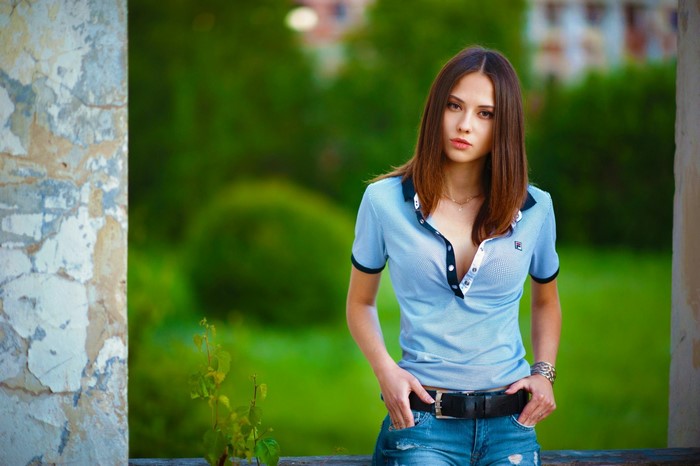 Portrait of Woman in Blue Shirt Against Green Background