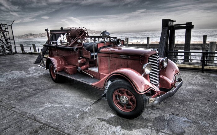 Vintage red fire truck parked by the water