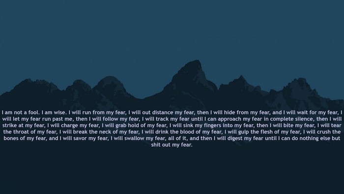 Motivational text about overcoming fear over mountain silhouette