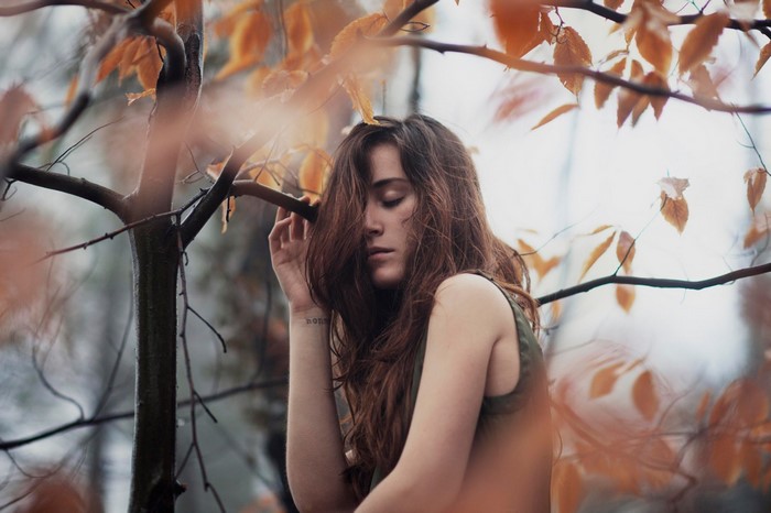Woman with auburn hair in autumn forest