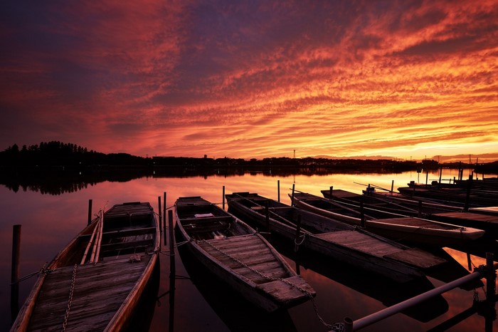 Boats docked on a lake at sunset with colorful sky