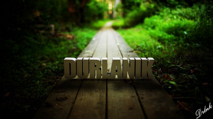 3D text DURLANIK on a wooden path in a forest