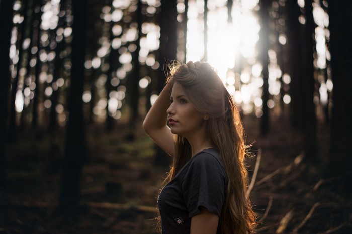 Woman in forest with sunlight