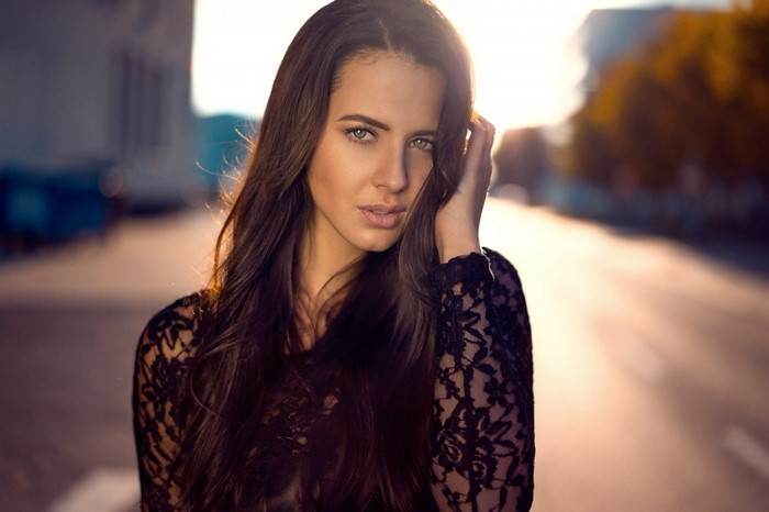 Woman with long brown hair in a black lace top